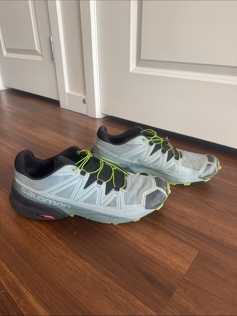 Salomon light blue trail running shoes with neon yellow laces